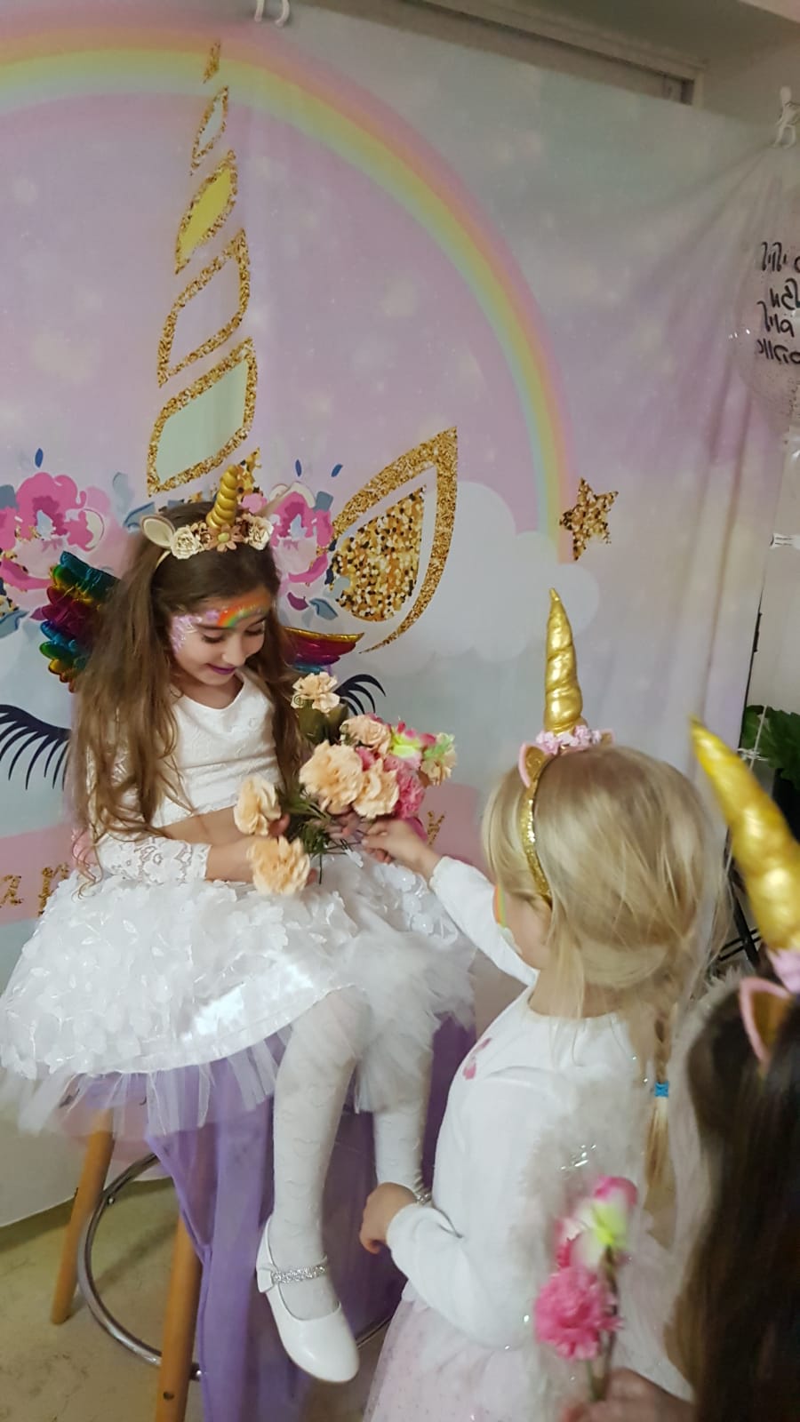 פינת צילום קונספט חד-קרן וקשת בענן במסיבת יום הולדת של אבקת פיות